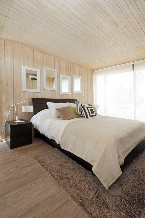 Dormitorio con cielo de madera ranurada